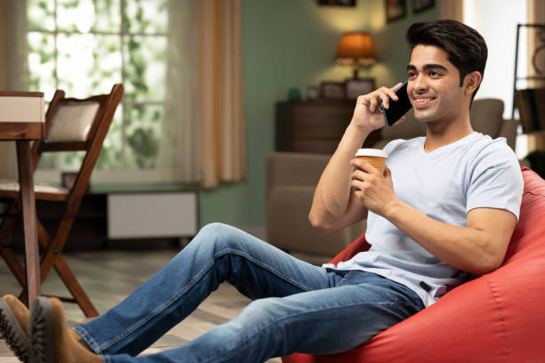 young man talking on phone, stock photo - coffee bean bag human hand imagens e fotografias de stock