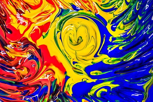 Colorful background with twirls made of red, yellow and blue acrylic paint