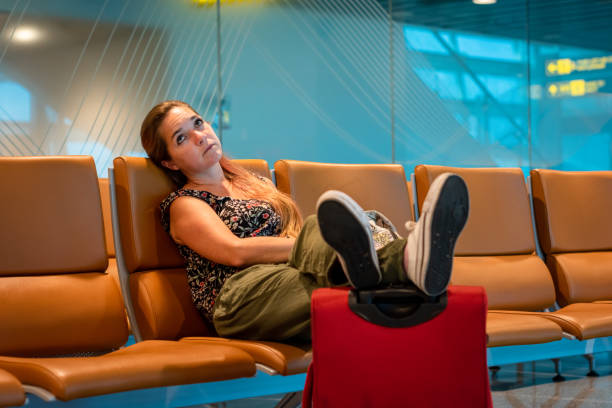 young woman at the airport waiting for her flight to depart. - depart imagens e fotografias de stock