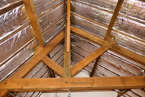 Aluminium foil roof insulation exposed in a vaulted ceiling after wood panelling removed