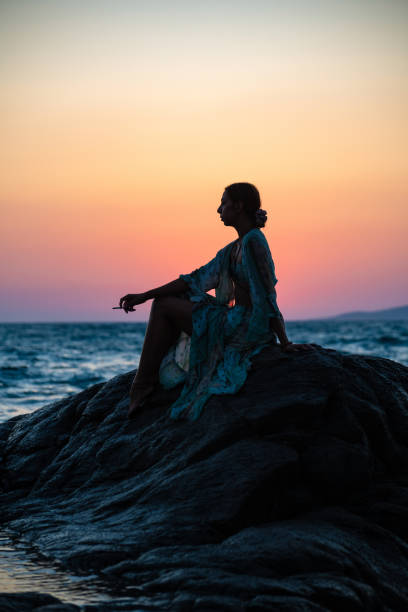 istock Sad Woman Sitting on the Cliffs on the Beach 1417333829