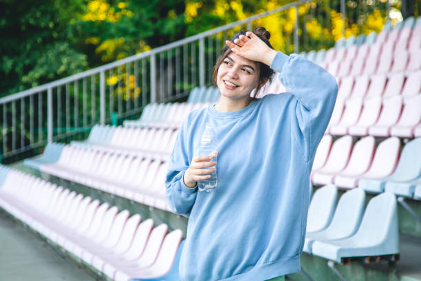 istock Attractive young female athlete drinks water after a workout. 1417335727
