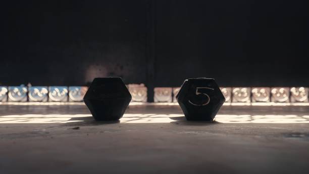 istock 5 kg dumbbells on the floor low angle front view - shadows and sun rays 1417336549
