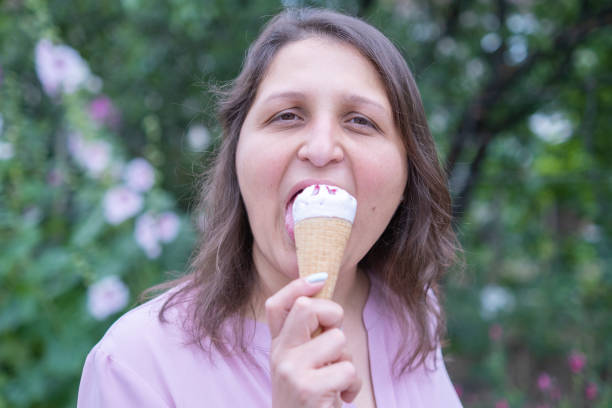 istock Young cheerful woman eating ice cream 1417336643