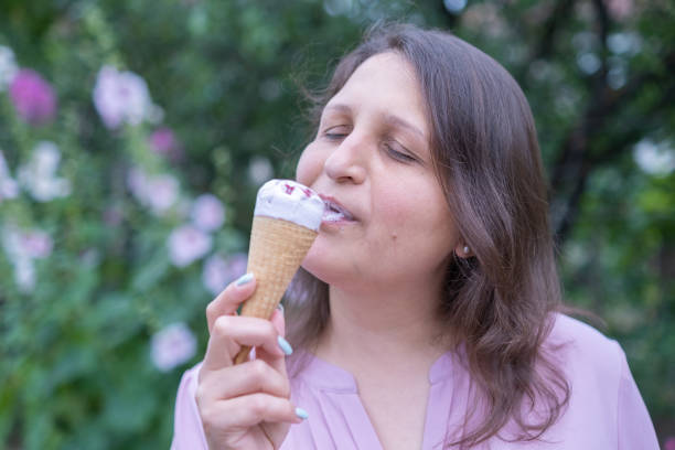 istock Young cheerful woman eating ice cream 1417336686