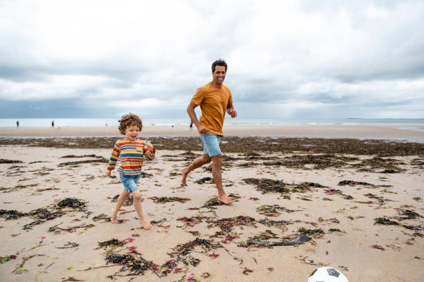 istock Playing Football on the Beach 1417336781