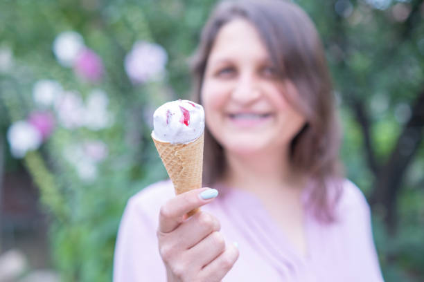 istock Young cheerful woman eating ice cream 1417336789