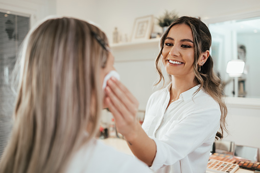 Makeup process. Professional artist applying make up on model face. Close up portrait of beautiful blonde woman in beauty saloon.