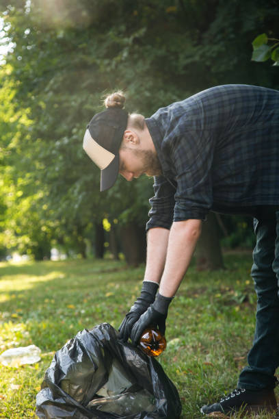 istock A young man with a trash bag in the forest cleans up plastic bottles. 1417339302