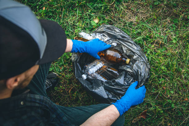 istock A man cleans up the forest, throws a bottle into a trash bag, close-up. 1417339319