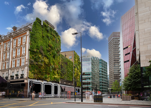 A range of sustainable buildings and modern architecture in the city, covered with lush green plants and foliage.