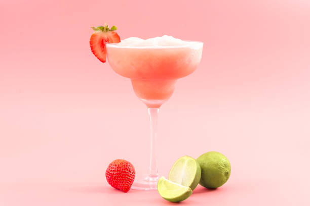 Mixed cocktails, party punch smoothies and frozen summer drinks concept with strawberry mojito or daiquiri in margarita glasses, strawberries and limes isolated on pink background Mixed cocktails, party punch smoothies and frozen summer drinks concept with strawberry mojito or daiquiri in margarita glasses, strawberries and limes isolated on pink background frozen rose stock pictures, royalty-free photos & images