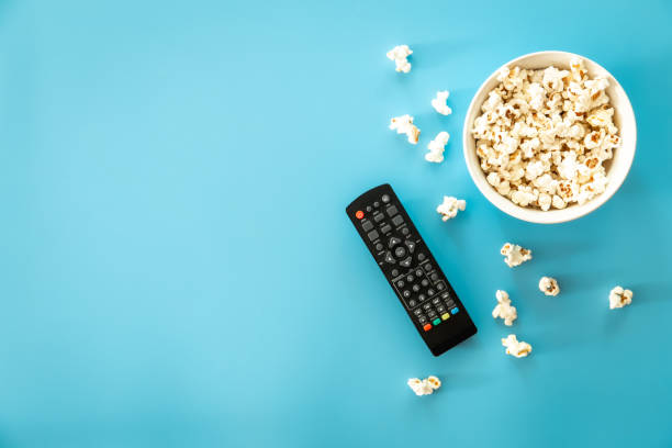 istock A bowl of popcorn, a TV remote on a blue background. 1417341638