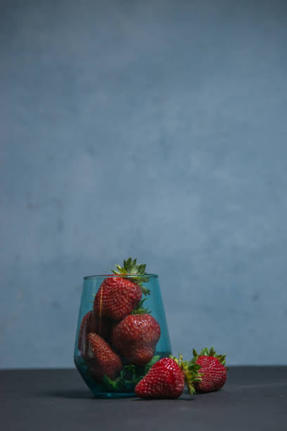 istock Fresh strawberries in a beautiful glass on a dark blue background. tonic. selective focus. atmospheric summer background, mood. advertising summer parties. promotional summer offers. 1417341903