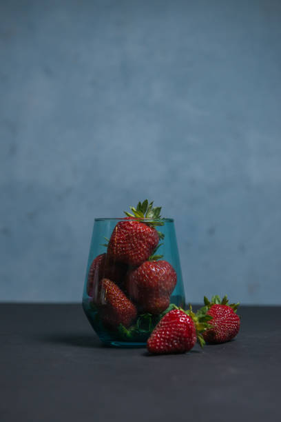 istock Fresh strawberries in a beautiful glass on a dark blue background. tonic. selective focus. atmospheric summer background, mood. advertising summer parties. promotional summer offers. 1417341911