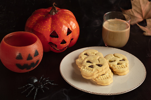 Funny delicious Halloween cookies on old dark rustic wooden table. Halloween background with cakes for party.