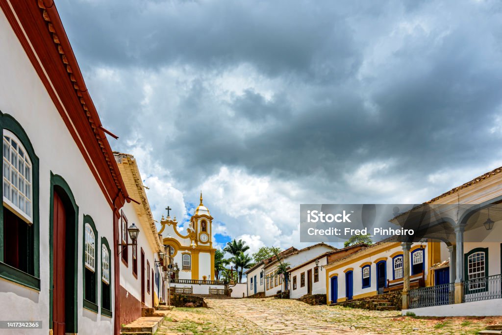 Street and old houses in the historic city of Tiradentes in Minas Gerais Street and old colonial style houses in the historic city of Tiradentes in Minas Gerais with a baroque church in the background Tiradentes - Brazil Stock Photo