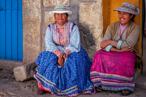 Two happy Peruvian women wearing a national clothing, near Chivay, Peru. Chivay is a town in the Colca valley, capital of the Caylloma province in the Arequipa region, Peru. Located at about 12,000 ft above sea level, it lies upstream of the renowned Colca Canyon.