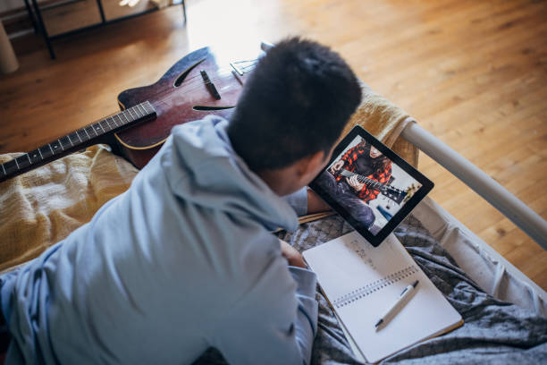 istock Man learning to play guitar online 1417344464