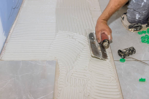 istock Using trowels to apply adhesive to concrete floors before tile-laying 1417345547