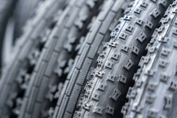 new bicycle tires in the storage. stack of black bike tires stock photo