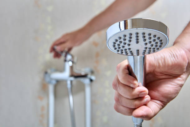 istock Plumber fixed leaking shower head on flexible hose. 1417346092