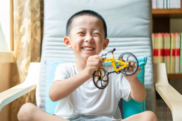 A Chinese baby playing with bicycle model