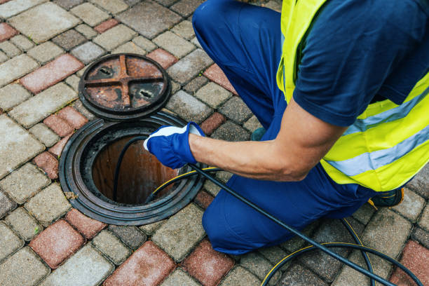 service worker cleaning blocked sewer line with hydro jetting stock photo