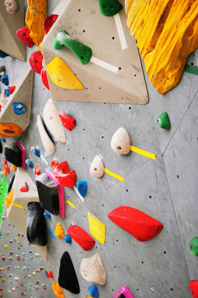 istock Artificial rock climbing bouldering wall showing various colored grips. 1417350266