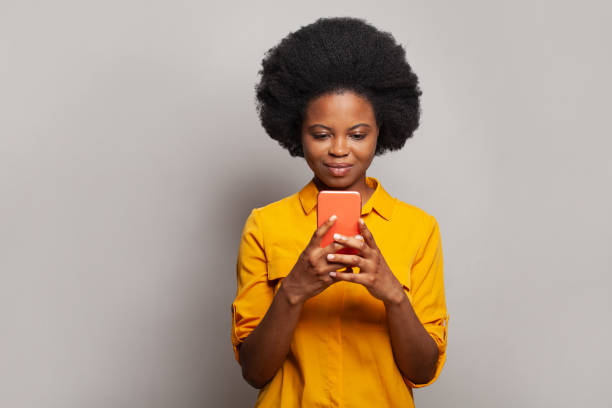 istock Cheerful friendly-looking woman messaging, browsing internet, using smartphone and shopping on white background 1417354705