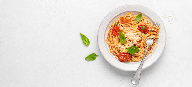 istock Spaghetti pasta with tomatoes and basil in ceramic plate on white background. 1417357279