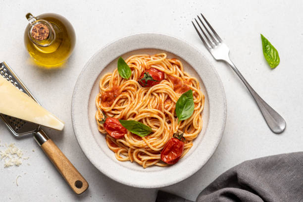istock Spaghetti pasta with tomatoes and basil in ceramic plate on white background. 1417357844