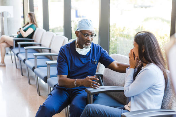 istock Doctor comforts female patient as he talks 1417359326