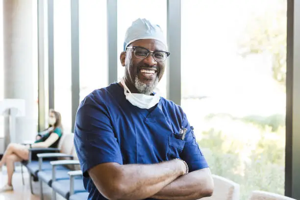 Photo of Doctor stands and crosses his arms for a headshot photo