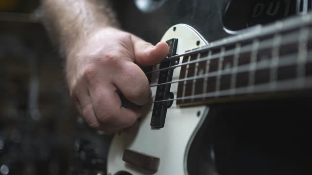 Close Up View Of Male Practicing On Guitar In Studio