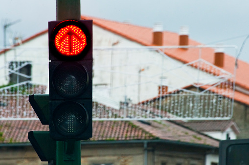 Red traffic light,  cityscape and rooftops background.  Copy space available on the right. Galicia, Spain.