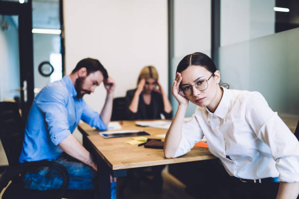 istock Fatigued colleagues working hard at desk at office 1417378838