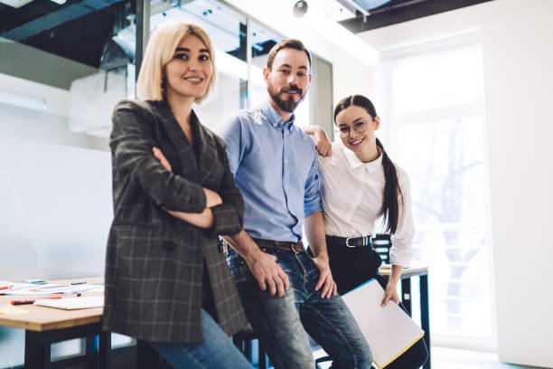 istock Cheerful colleagues smiling and leaning on table in office 1417378842