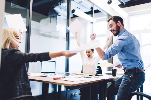 istock Cheerful team work rejoicing with raised hands at office 1417379472