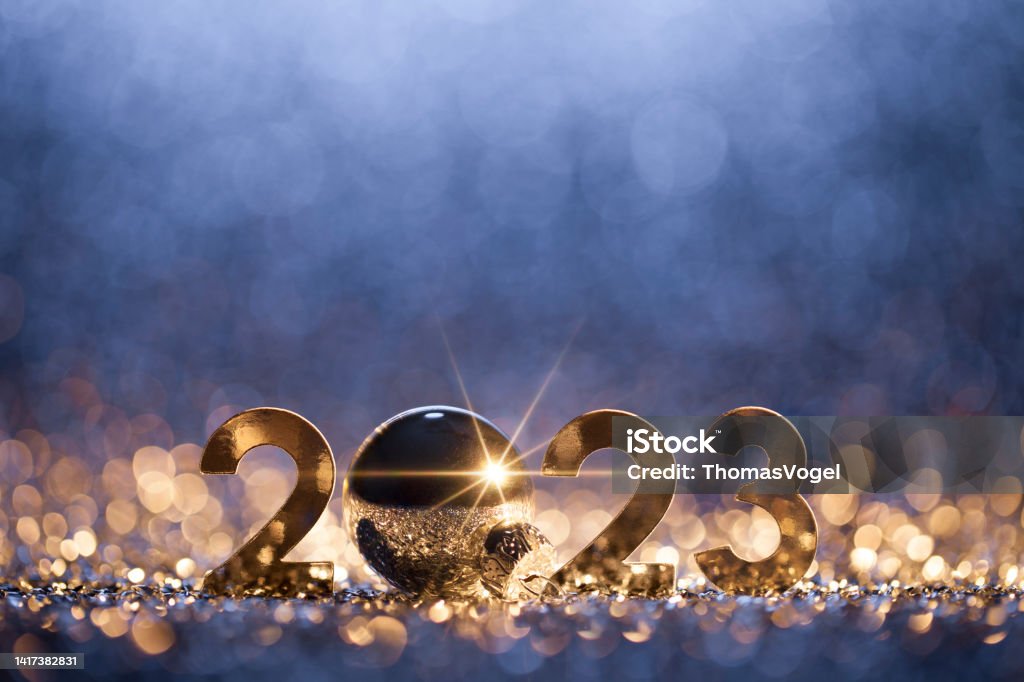 New Year 2023 Christmas Background - Gold Blue Party Celebration Abstract Christmas / New Year 2023 background. Metallic numbers and a Christmas ornament on shiny stars, glitter and defocused lights in a yellow blue contrast. Native image size: 5616x3744 2023 Stock Photo