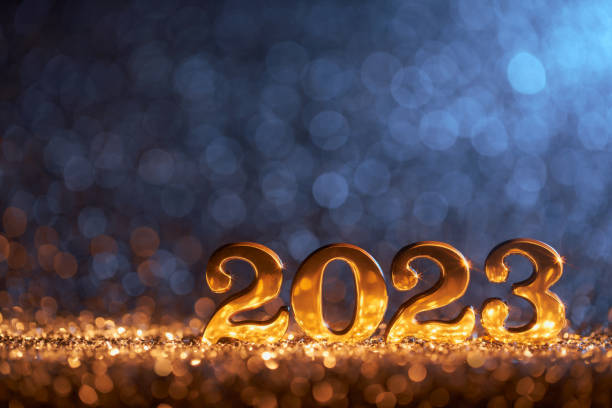 Glänzende, goldene Zahl 2023 und auf Glitzer und unscharfen Lichtern. Native Bildgröße: 7952x5304