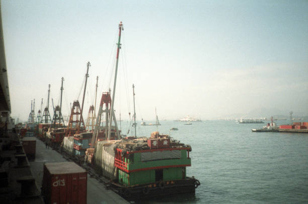 British Hong Kong, China - 1983: A vintage 1980's Fujifilm negative film scan of a collection of docked Chinese shipping cargo container ships in the bay of Hong Kong.