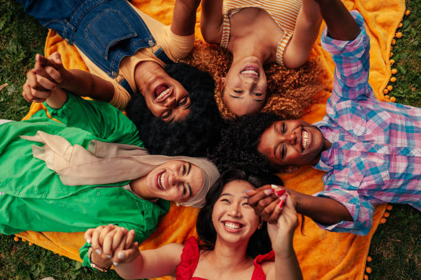 istock Girls lying in circle on grass holding hands 1417383820