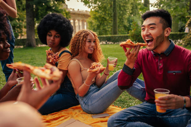 istock Young adults eating pizza on picnic 1417383822