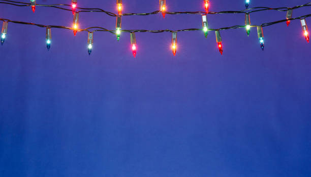 Christmas lights string on blue background with copy space stock photo