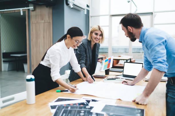 istock Smiling coworkers working with project on paper 1417387671