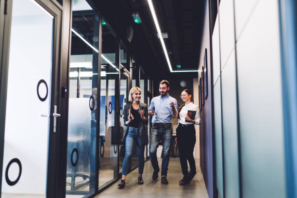 istock Cheerful colleagues smiling and walking to meeting 1417387719