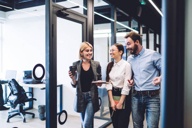 istock Colleagues with coffee and notebooks walking in office corridor 1417387750