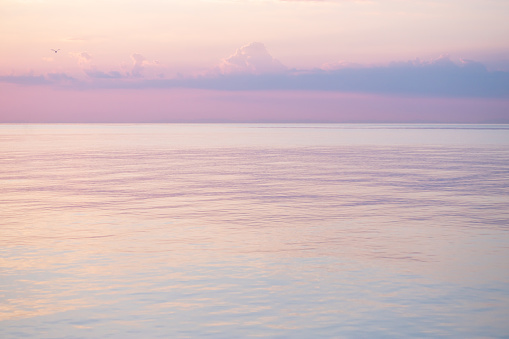 Blurred background sea and sky at sunrise. The sea and the sky are pearly. Beautiful backdrop for your design.