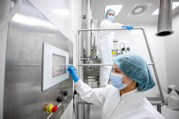 istock Two fully equipped coworkers in protective workwear seen in a pharmaceutical laboratory 1417391857